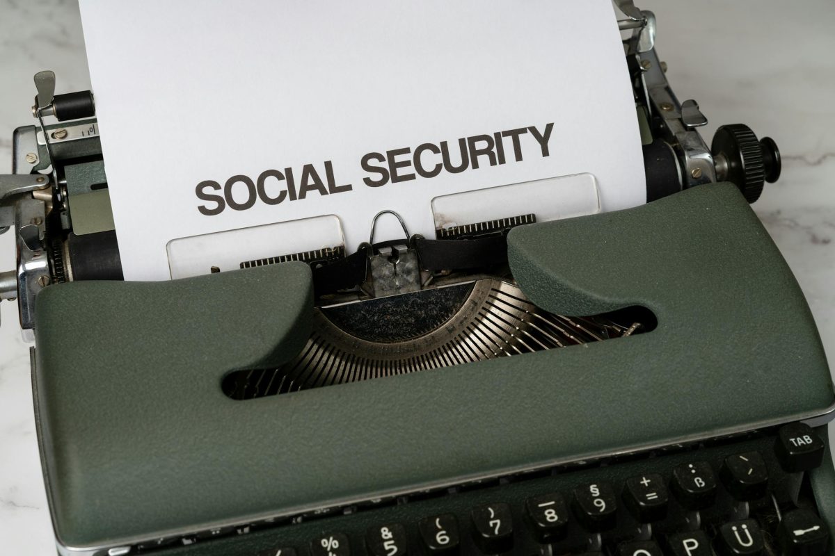 Close-up of a vintage typewriter typing 'SOCIAL SECURITY' on paper.