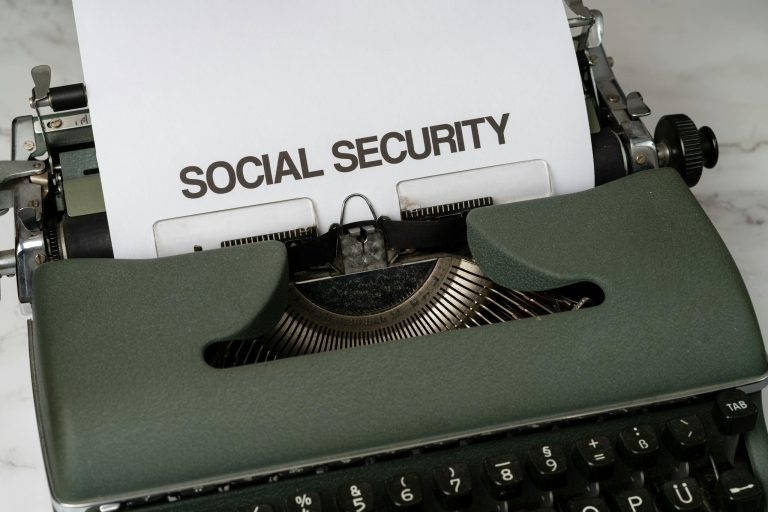 Close-up of a vintage typewriter typing 'SOCIAL SECURITY' on paper.